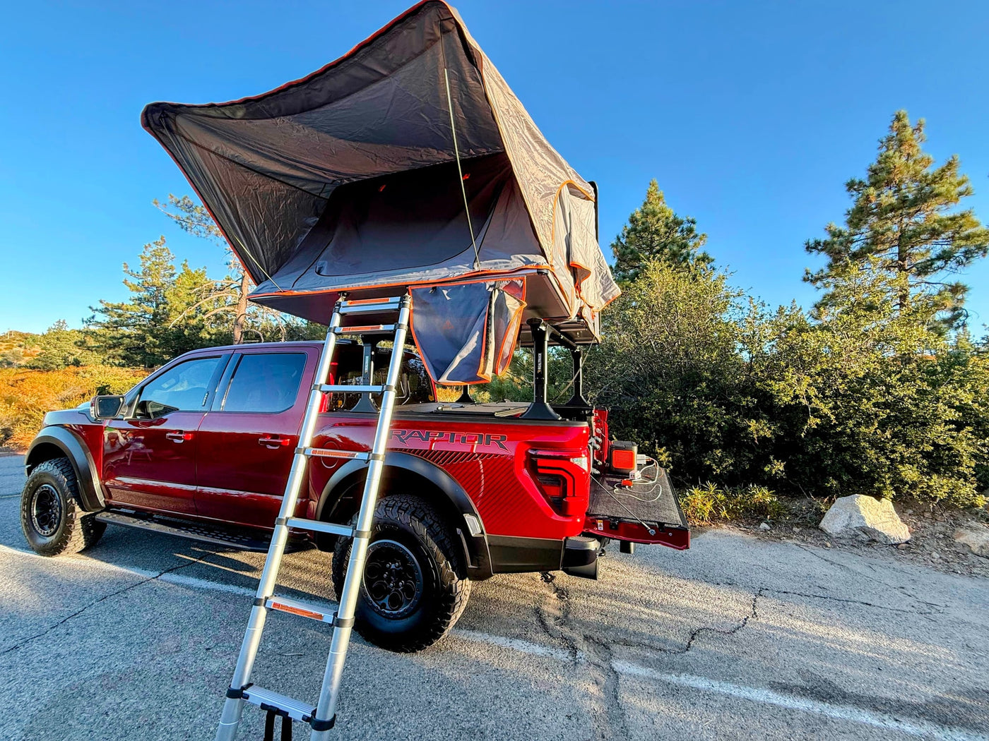 viewing a house and blue sky. Dashboard details & navigation for a potential rv rental journey.|Red pickup truck bed with open tailgate & deployed step/extender. Ladder rack system ready for camping/RV rental gear.|Clean pickup truck bed with spray-in liner and tonneau cover — photo 12