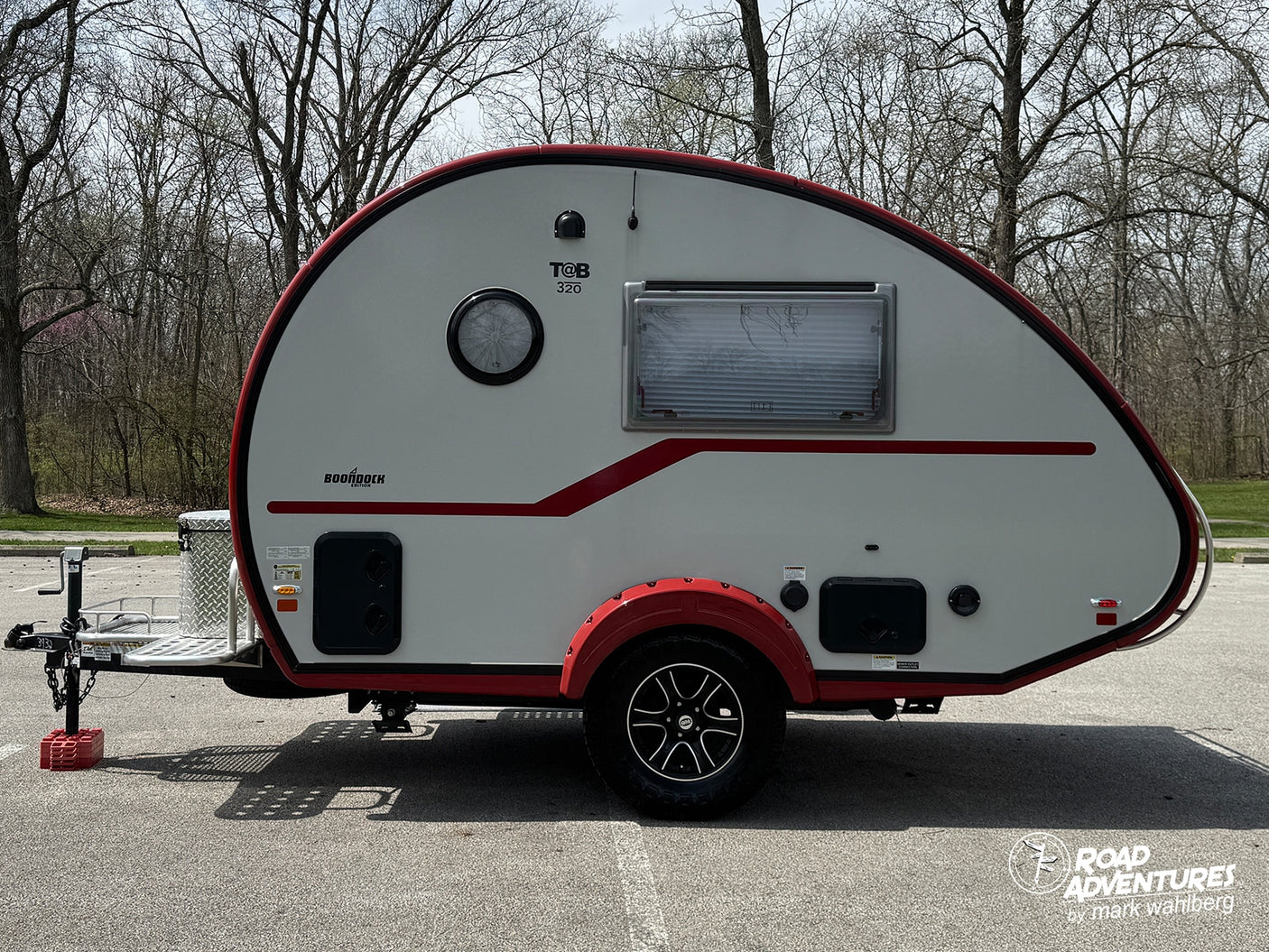 This white T@B 320 Boondock teardrop camper, featuring red trim and fender, is ready for your next rv rental trip.