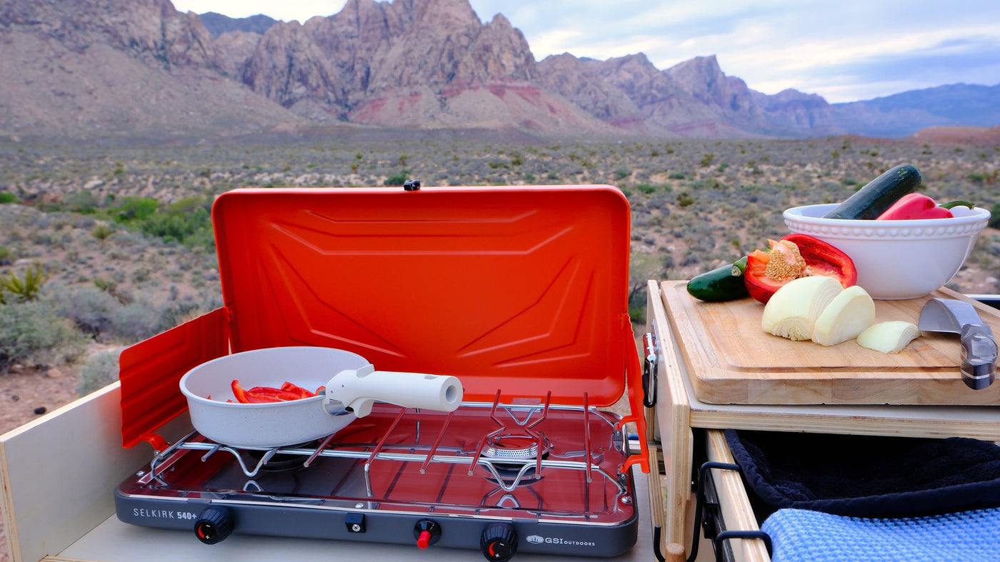 Camp kitchen cooking fresh veggies (onions, peppers) on a portable stove in a desert mountain landscape, perfect for an RV rental. — photo 10