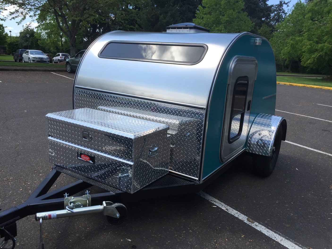 Teal & aluminum teardrop camper RV rental with front diamond plate storage boxes. Ready for road trips!