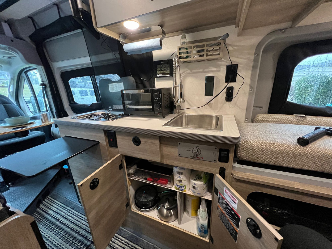 designed for efficient use of space.|Inside this rv rental camper van: a cozy dining area with two tables