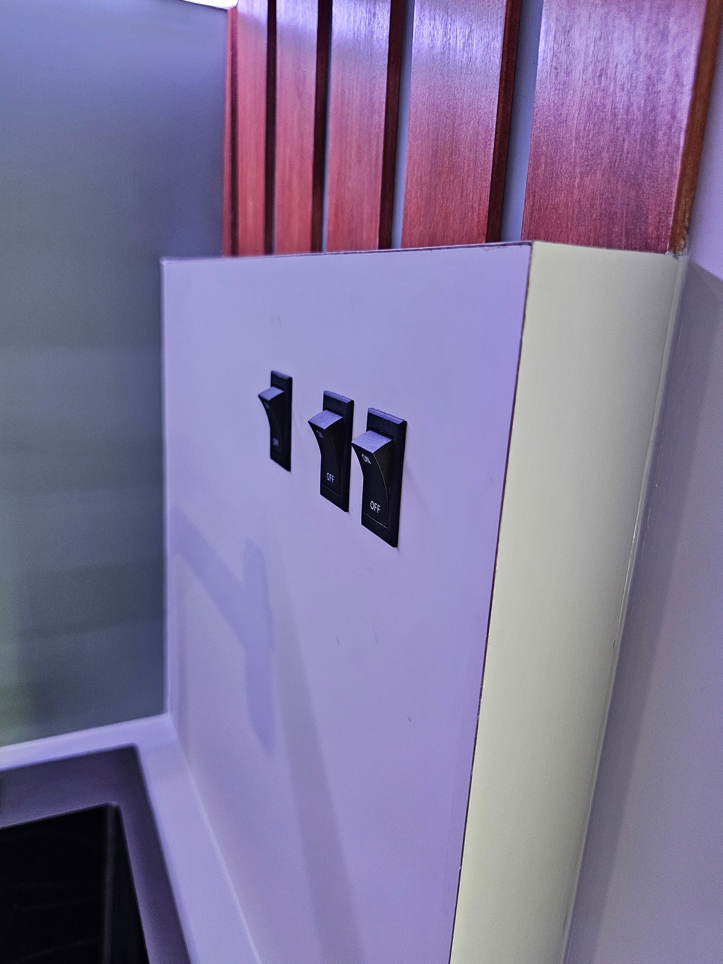 Control features in your RV rental with these three ON/OFF rocker switches, set against a modern panel with wood accents.