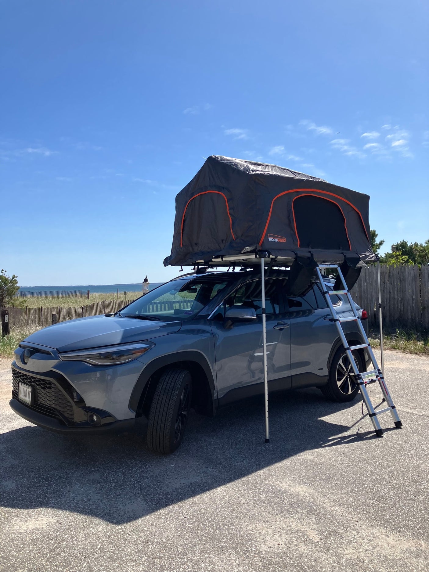 This gray Toyota Corolla Cross with a Roofnest roof tent offers a unique alternative to an rv rental for beachside adventures.