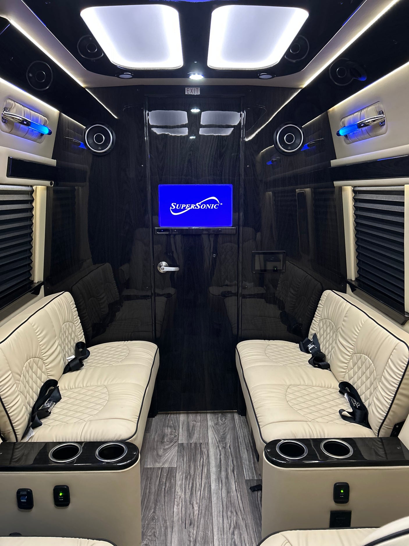 Experience comfort in this luxury **rv rental** featuring plush white seats, ambient lighting, and a Supersonic TV.