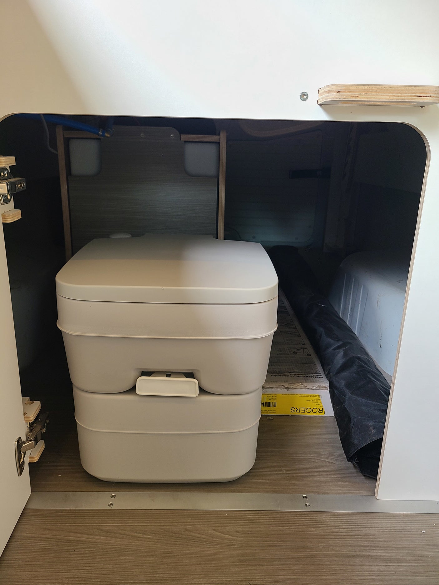 This rv rental features a compact portable toilet, cleverly integrated for discreet and convenient waste solutions on the go.
