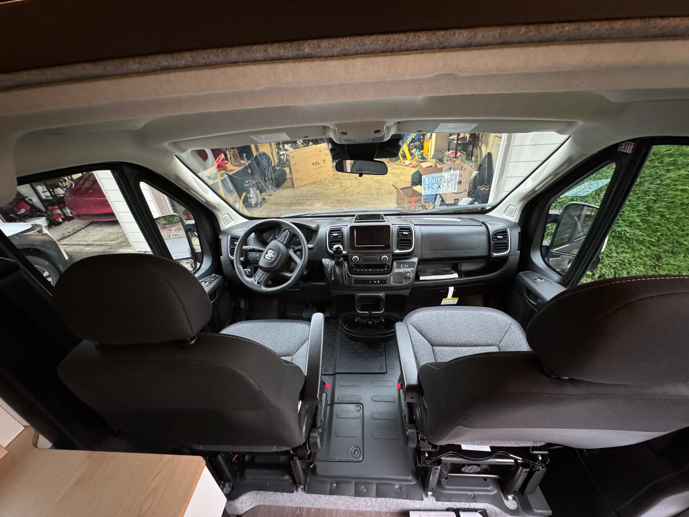 Front cabin view of an RV rental van, showing the dashboard, steering wheel, and comfortable seats. Ideal for road trips!