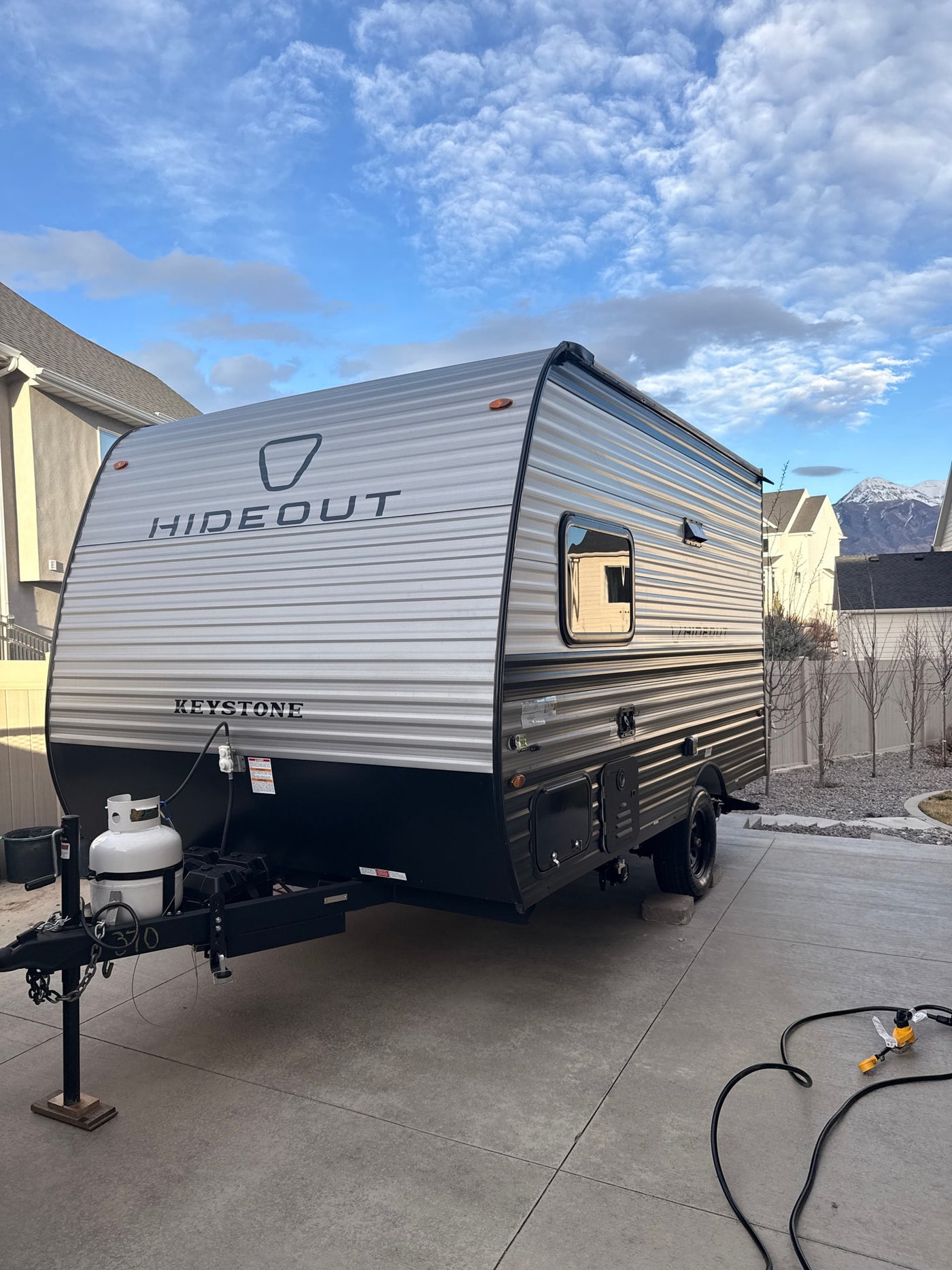 A sleek silver and black Keystone Hideout travel trailer, an ideal RV rental for your next outdoor adventure. — photo 1