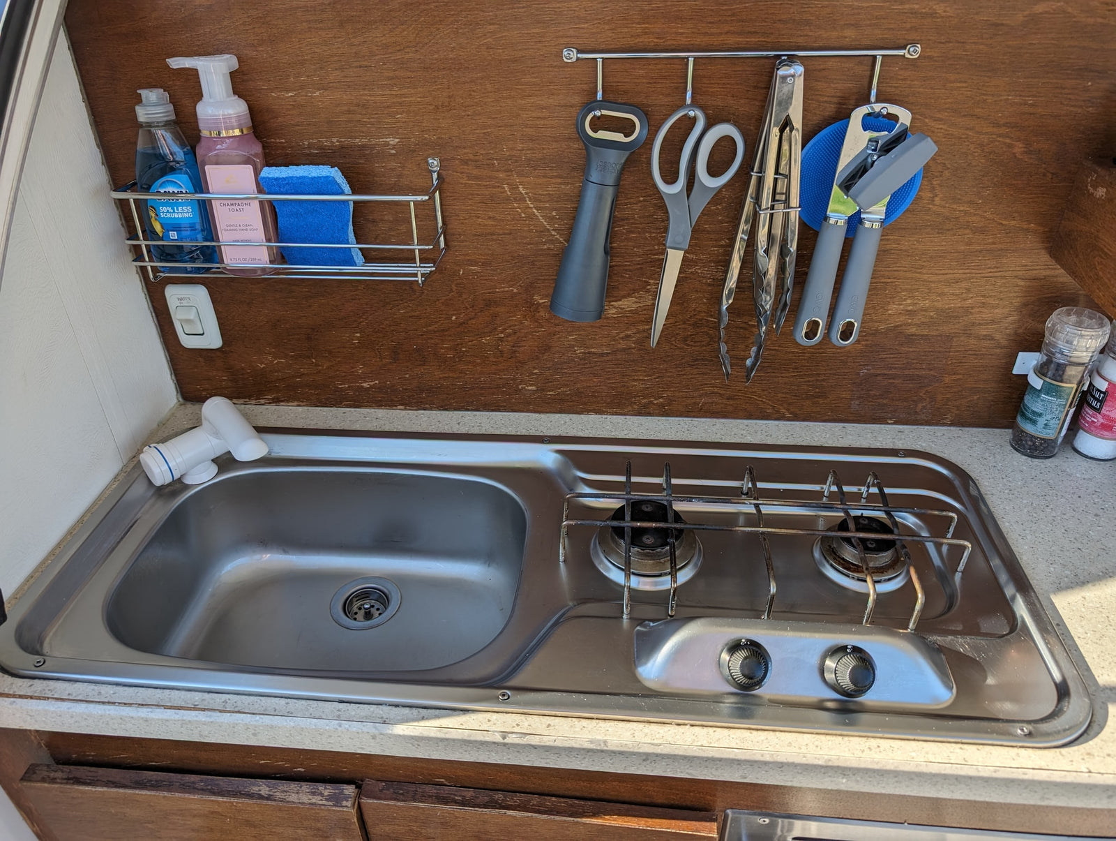 & wood cabinets. View out to a fenced yard.|Inside a cozy RV rental: bed with pillows