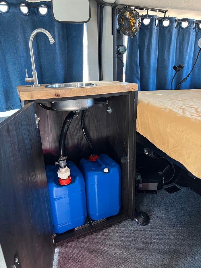 This RV rental offers a clever kitchenette with sink, hidden water tanks, and a cozy bed for comfortable travel.