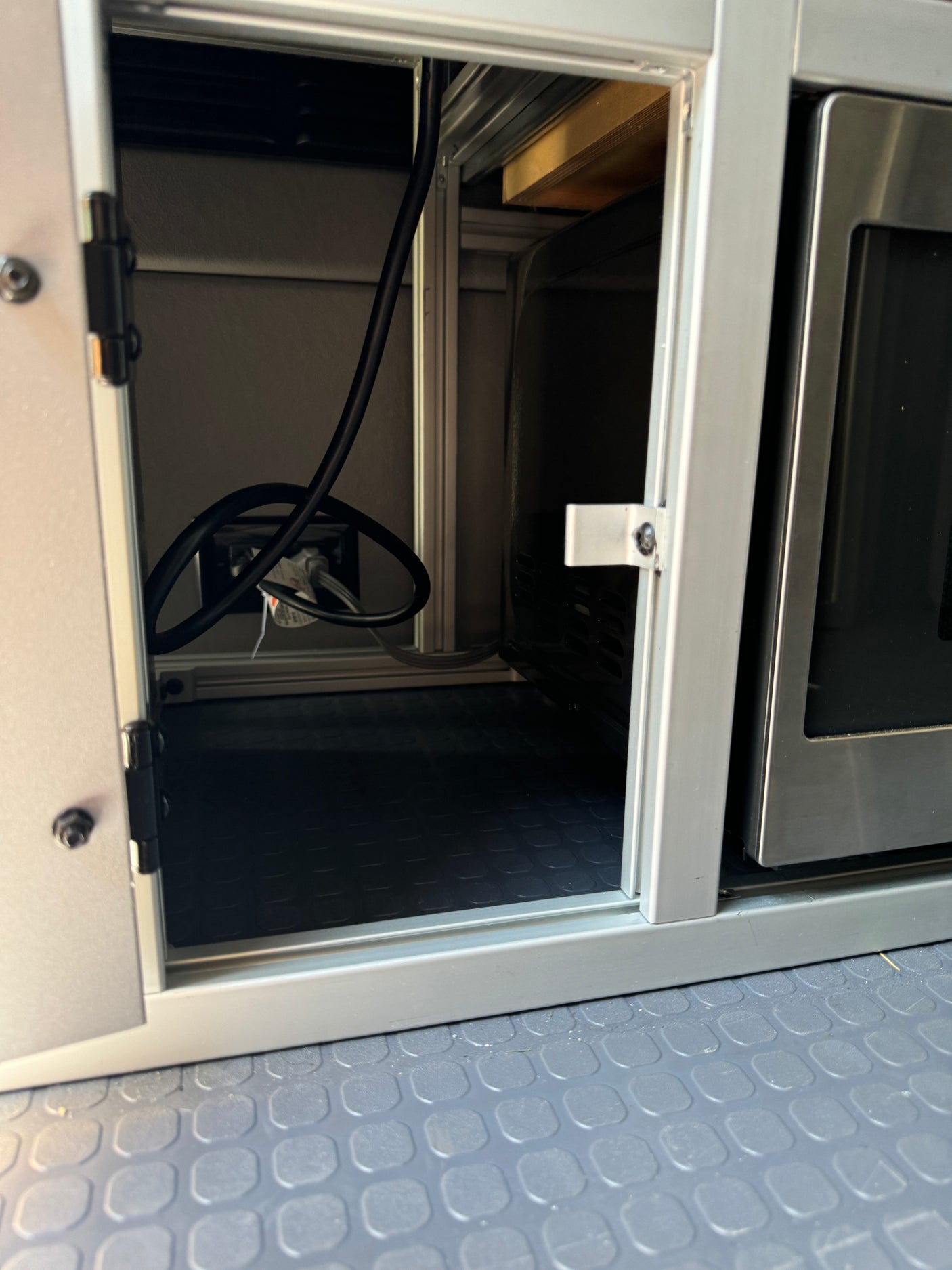 RV rental kitchen area featuring modular storage with a microwave and power outlet, ideal for compact living.