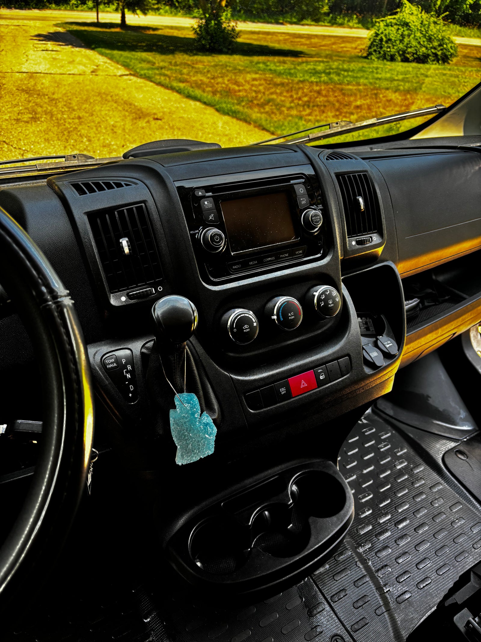 RV rental dashboard interior: media screen, climate controls, gear shifter (with TOW HAUL), cupholders, and air freshener.