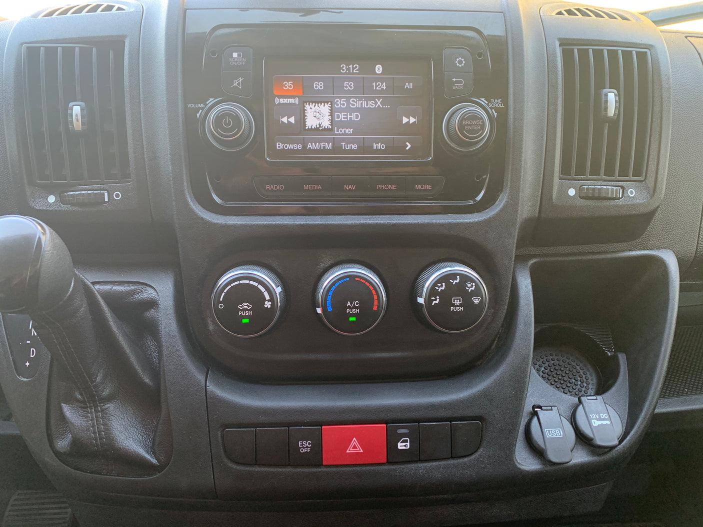 RV rental dashboard: central infotainment, climate, gear shifter, hazard lights, USB, and 12V outlets.