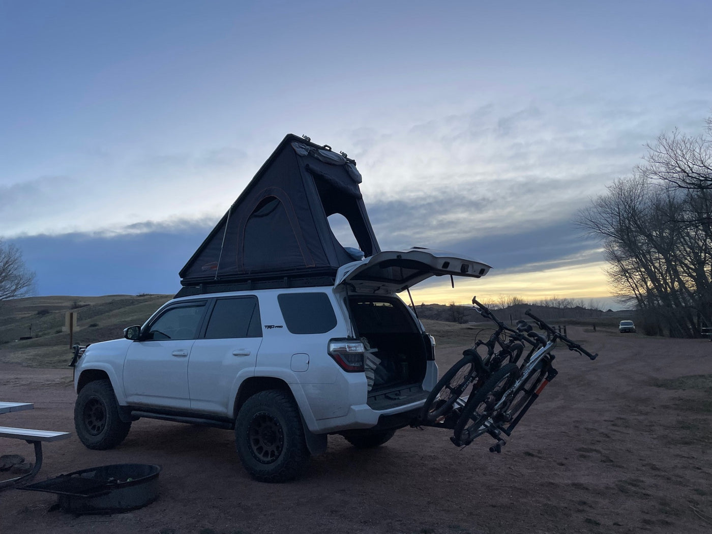 White 4Runner with rooftop tent & bikes at a scenic campsite. Perfect for outdoor adventures, offering more flexibility than an RV rental. — photo 16