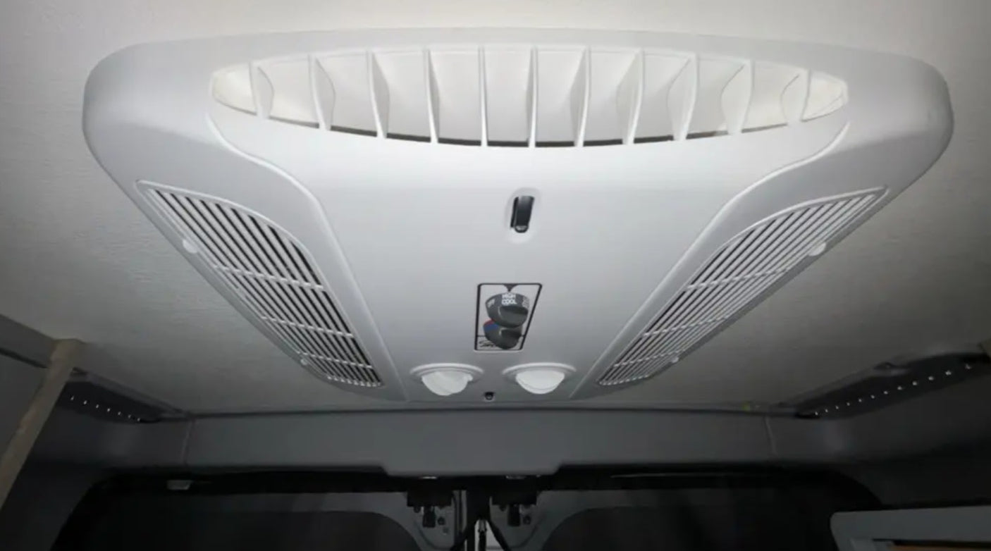 driver's seat visible. View of a house outside.|RV rental interior: Driver's perspective of the dashboard