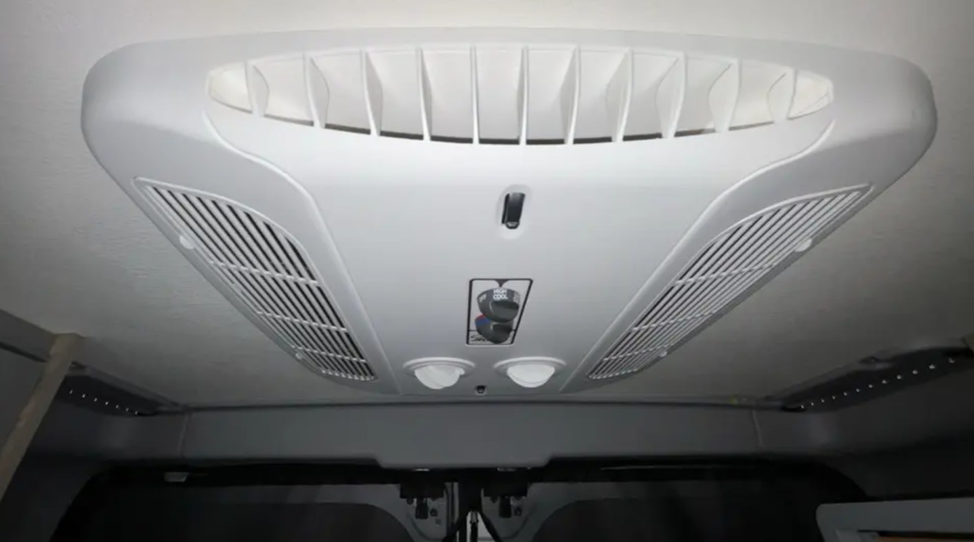 driver's seat visible. View of a house outside.|RV rental interior: Driver's perspective of the dashboard