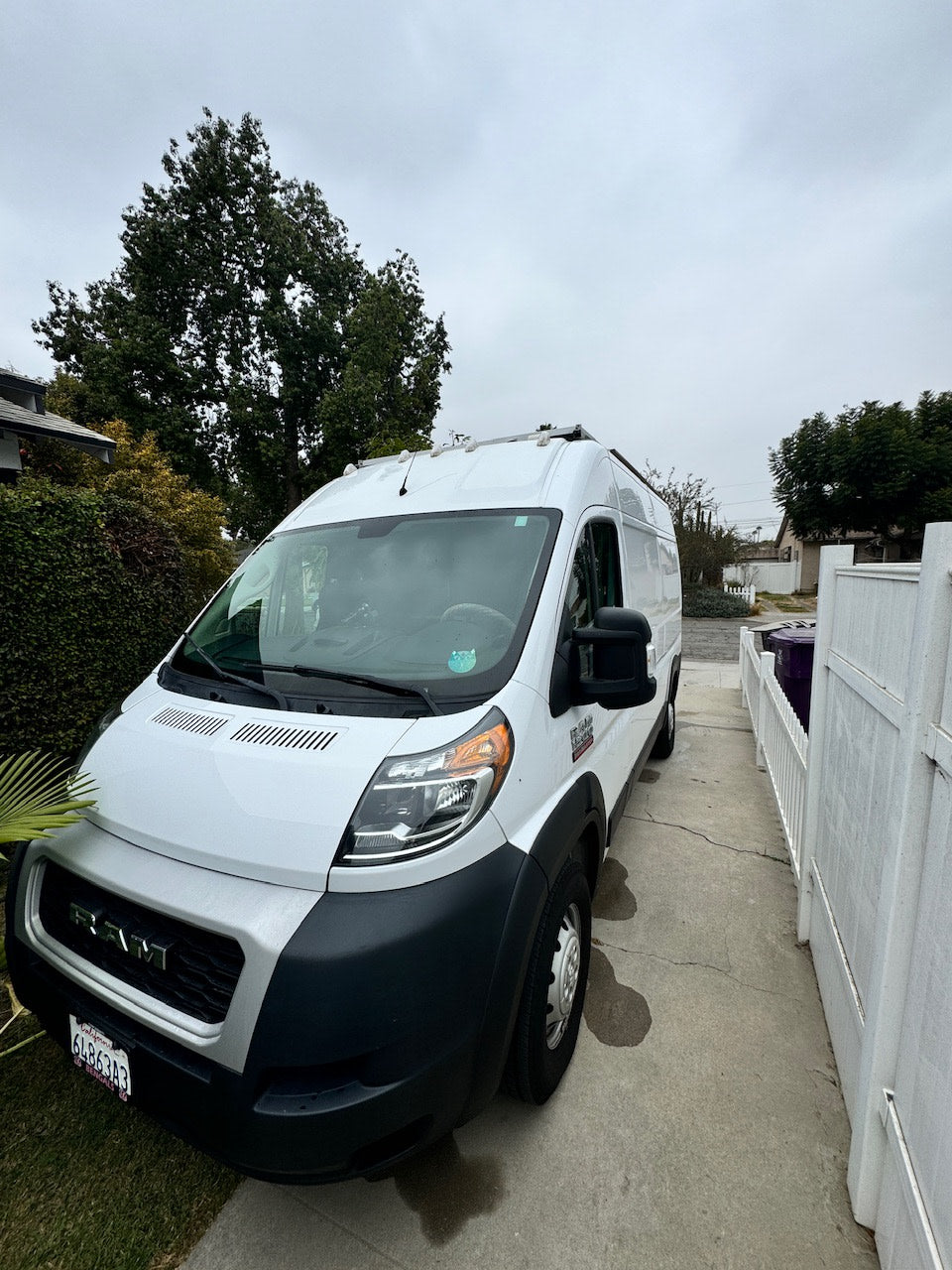 White Ram ProMaster camper van parked on a driveway. An ideal RV rental for travel adventures.