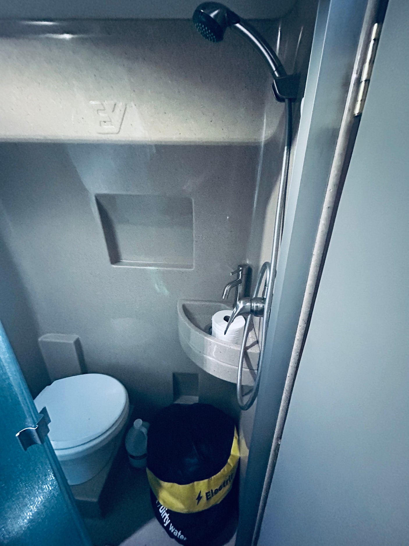 Experience practical living in this RV rental's compact wet bath, featuring a toilet, sink with TP, and shower.