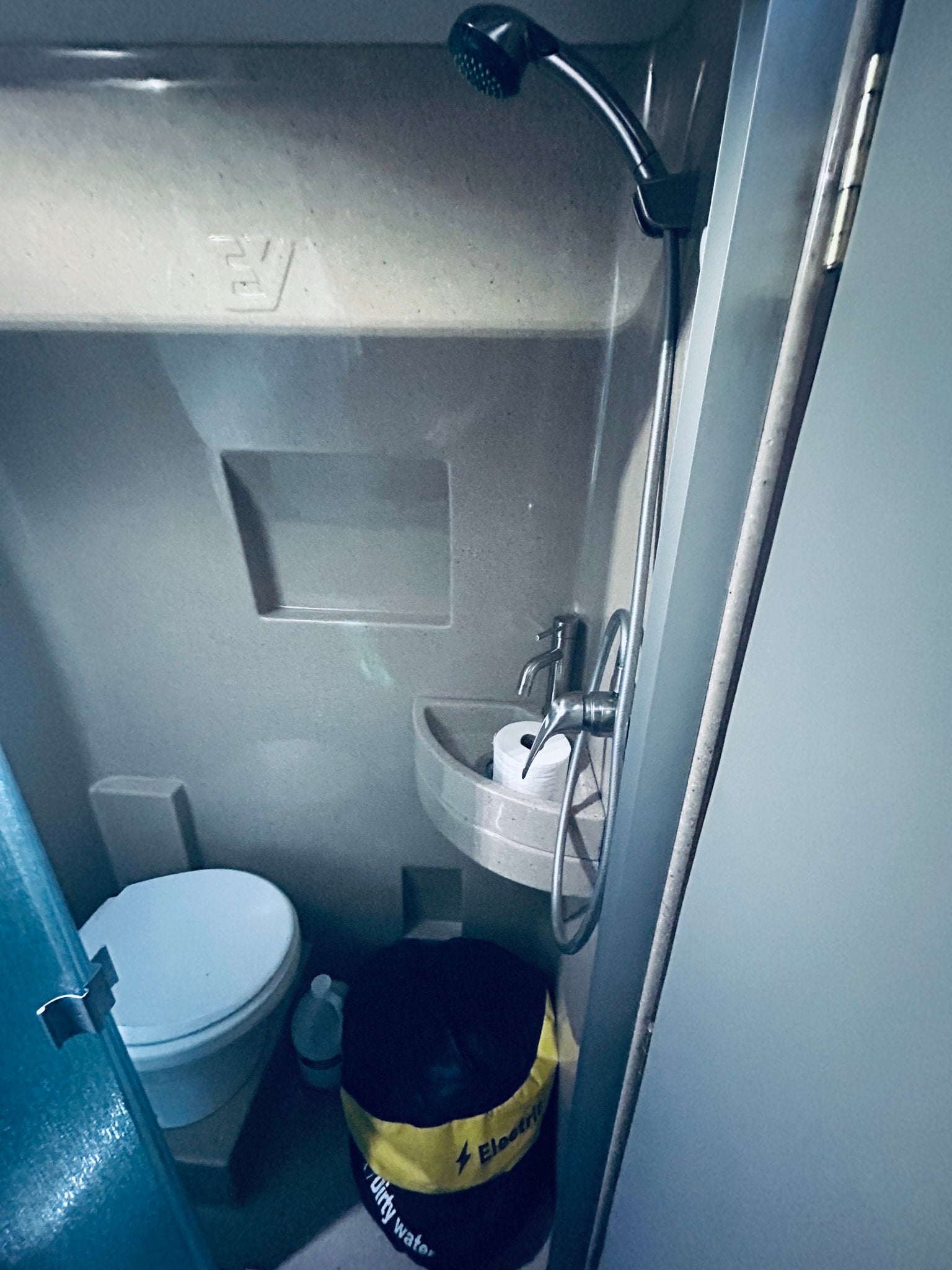 Experience practical living in this RV rental's compact wet bath, featuring a toilet, sink with TP, and shower.