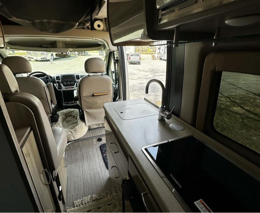 and a mounted TV for your next adventure.|Inside a modern RV rental: light-colored seating