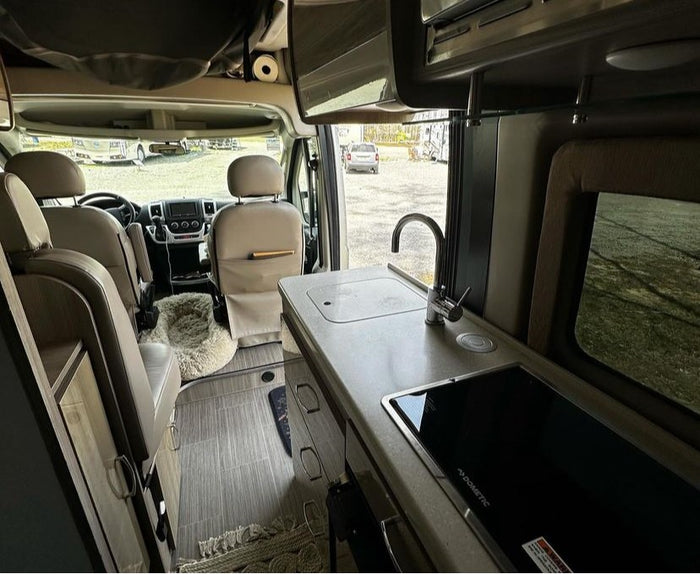and a mounted TV for your next adventure.|Inside a modern RV rental: light-colored seating
