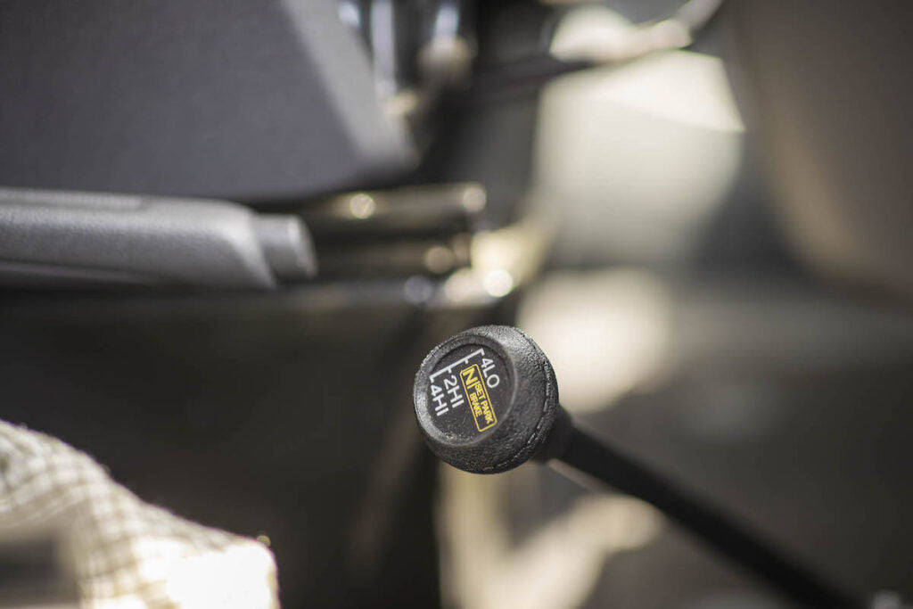 An RV rental's 4x4 transfer case shifter, showing 4LO, N (neutral), 2HI, and 4HI settings for varied terrain driving.