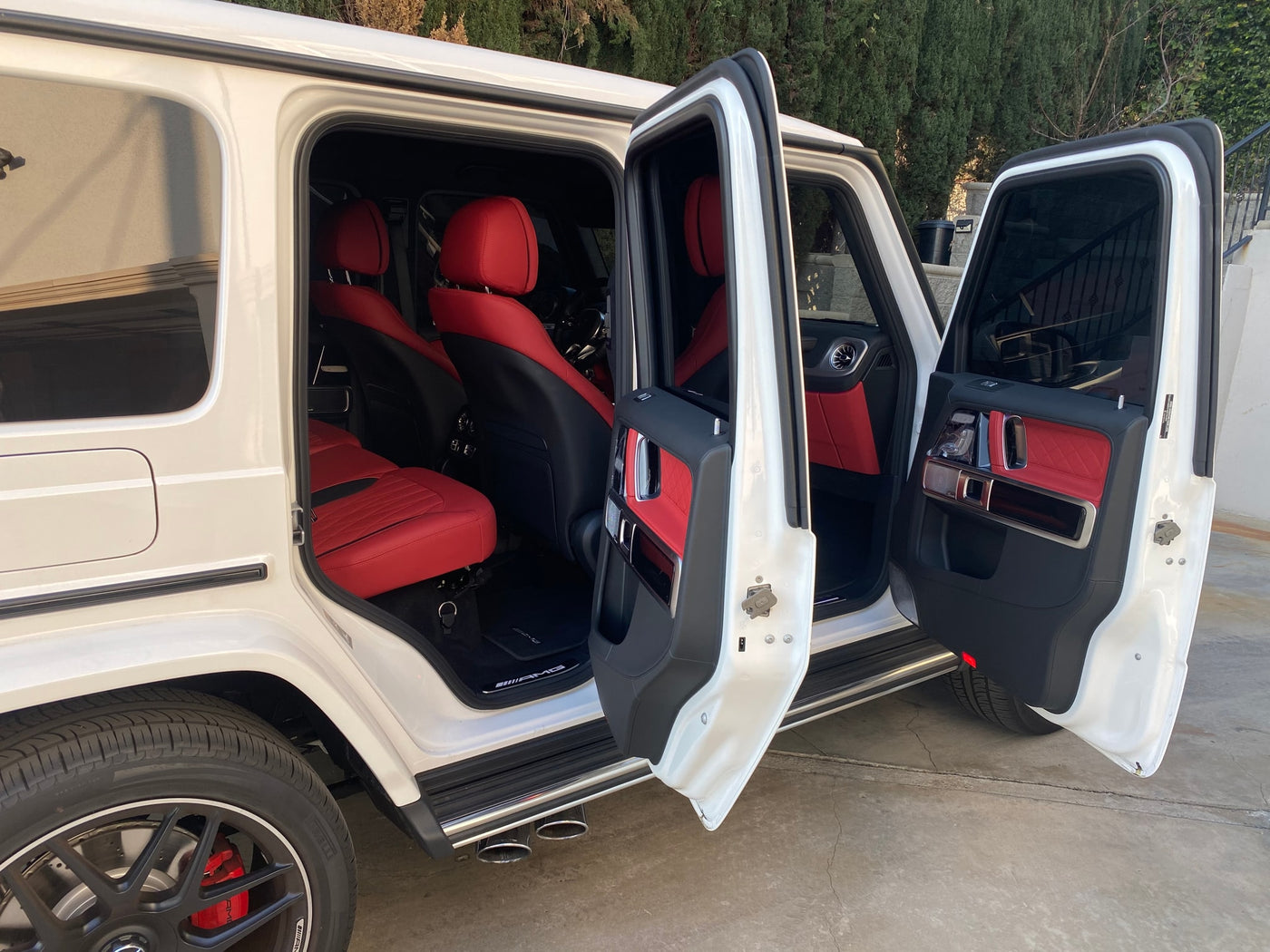 Experience luxury beyond an **rv rental**! This white G-Wagen SUV showcases a striking red leather interior with all doors open. — photo 5