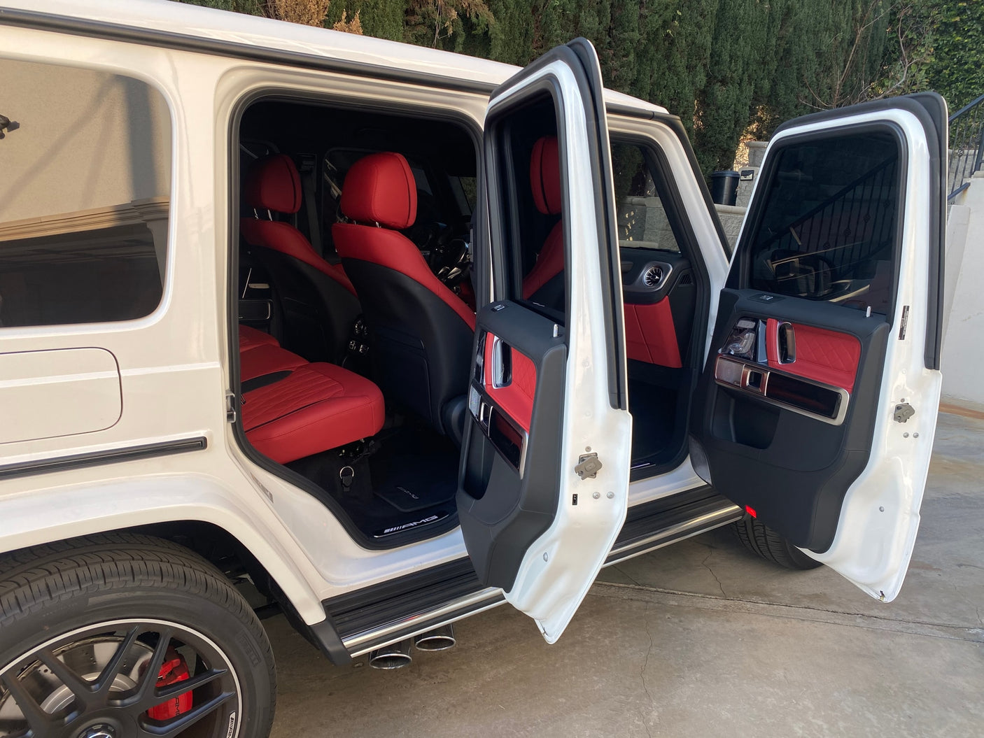 Experience luxury beyond an **rv rental**! This white G-Wagen SUV showcases a striking red leather interior with all doors open.
