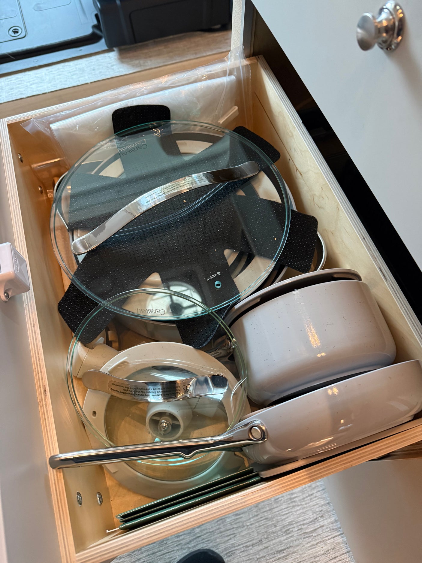 RV rental kitchen: A compact drawer neatly organizes Caraway pots, pans, and lids for efficient cooking essentials.