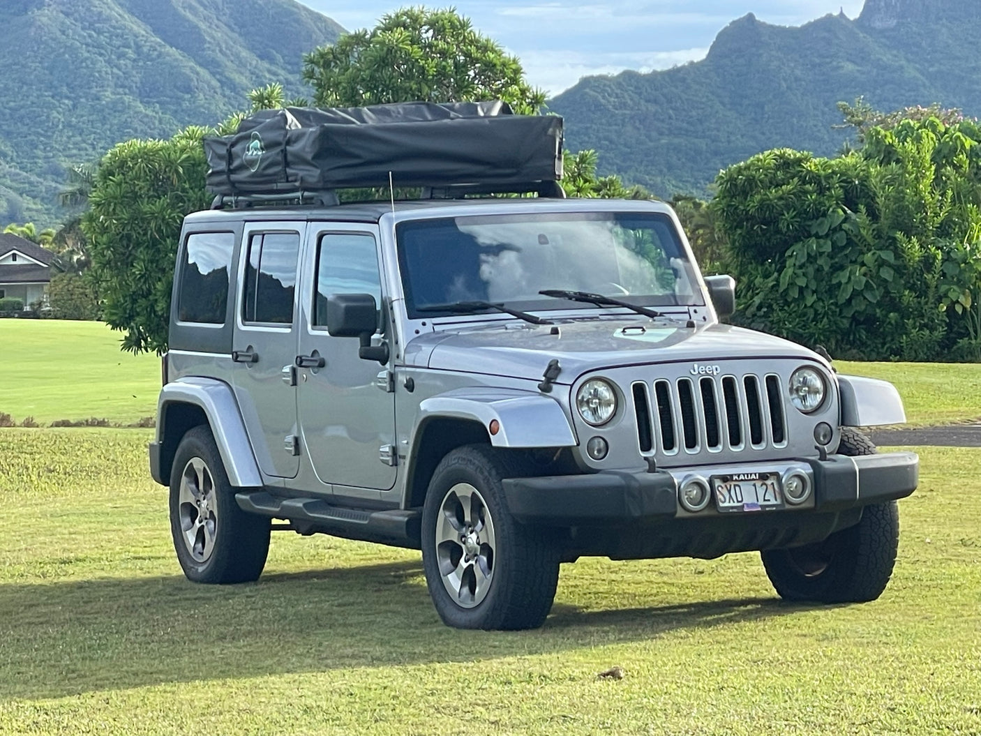 Silver Jeep Wrangler with a rooftop tent, offering a unique rv rental experience for scenic adventure travel.