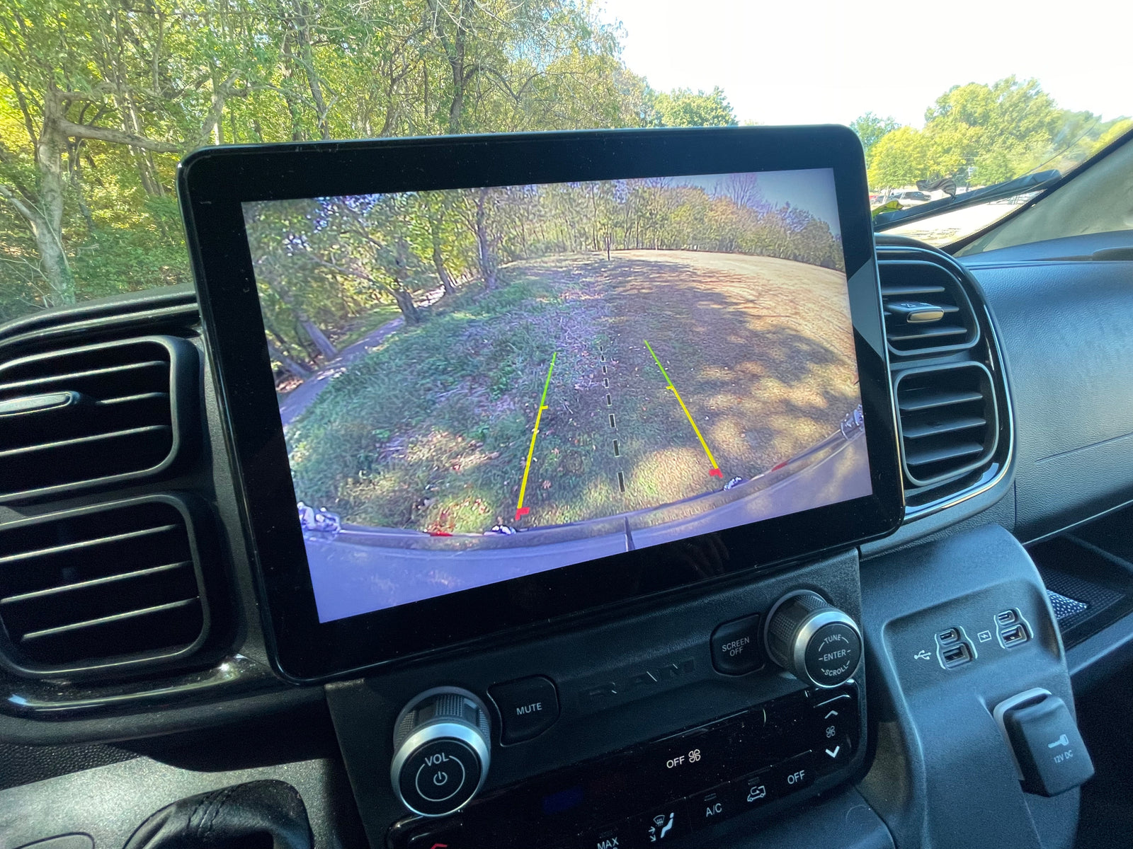 Inside an rv rental: dashboard screen displays backup camera view. Physical controls for audio, climate, & multiple USB ports are visible.