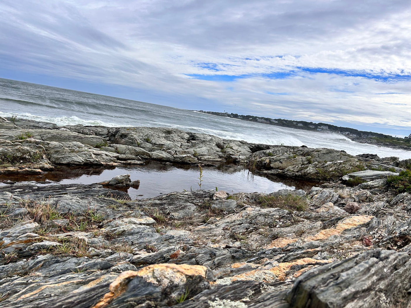 awaits adventure in a snowy waterfront setting with its door open.|Low-angle view of rugged rocks surrounding a still pool