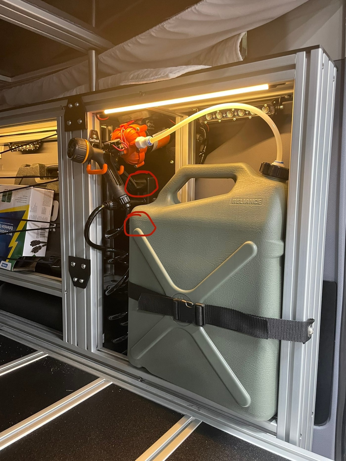 Custom water system in an RV rental: green Reliance jug, pump, and nozzle for on-the-go hydration. — photo 17