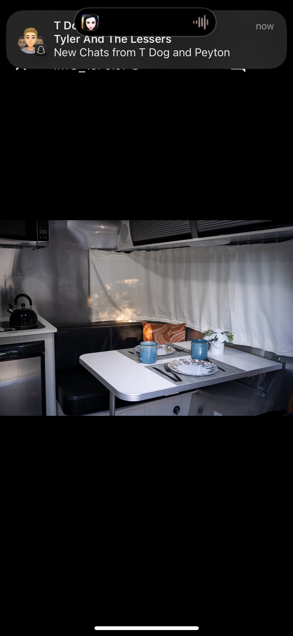 Experience comfort in this RV rental! Interior features a dining area for two, complete kitchen, and sleek metallic walls. — photo 6
