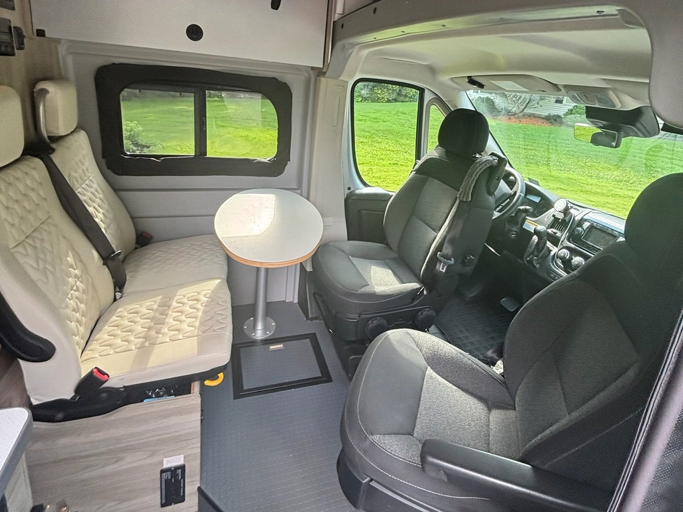 and a slatted bed frame by the screened rear doors.|RV rental interior showing a flexible bed/bench on the left — photo 7