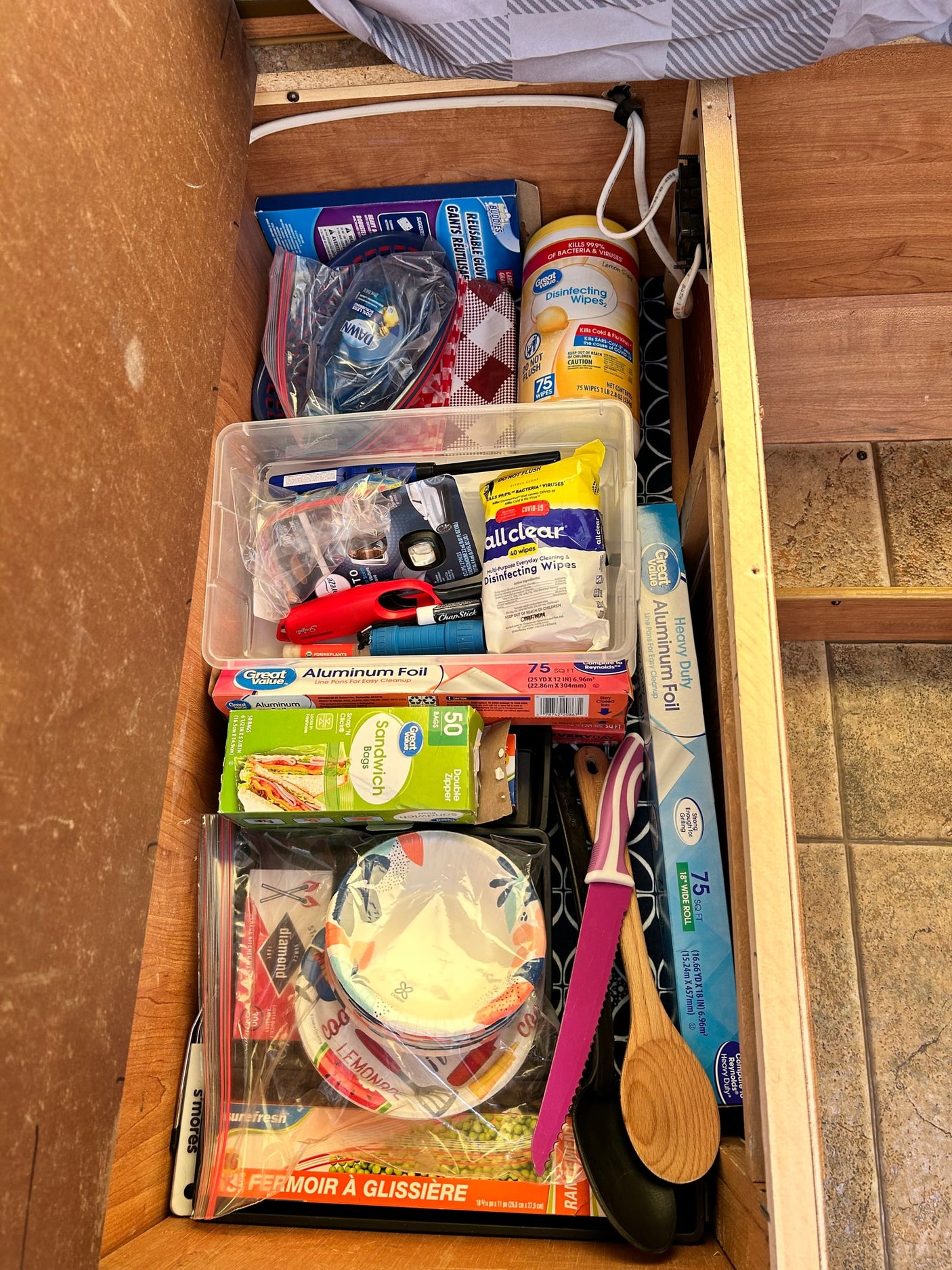 Organized RV rental storage: camping supplies, kitchen essentials, and cleaning products neatly stowed.