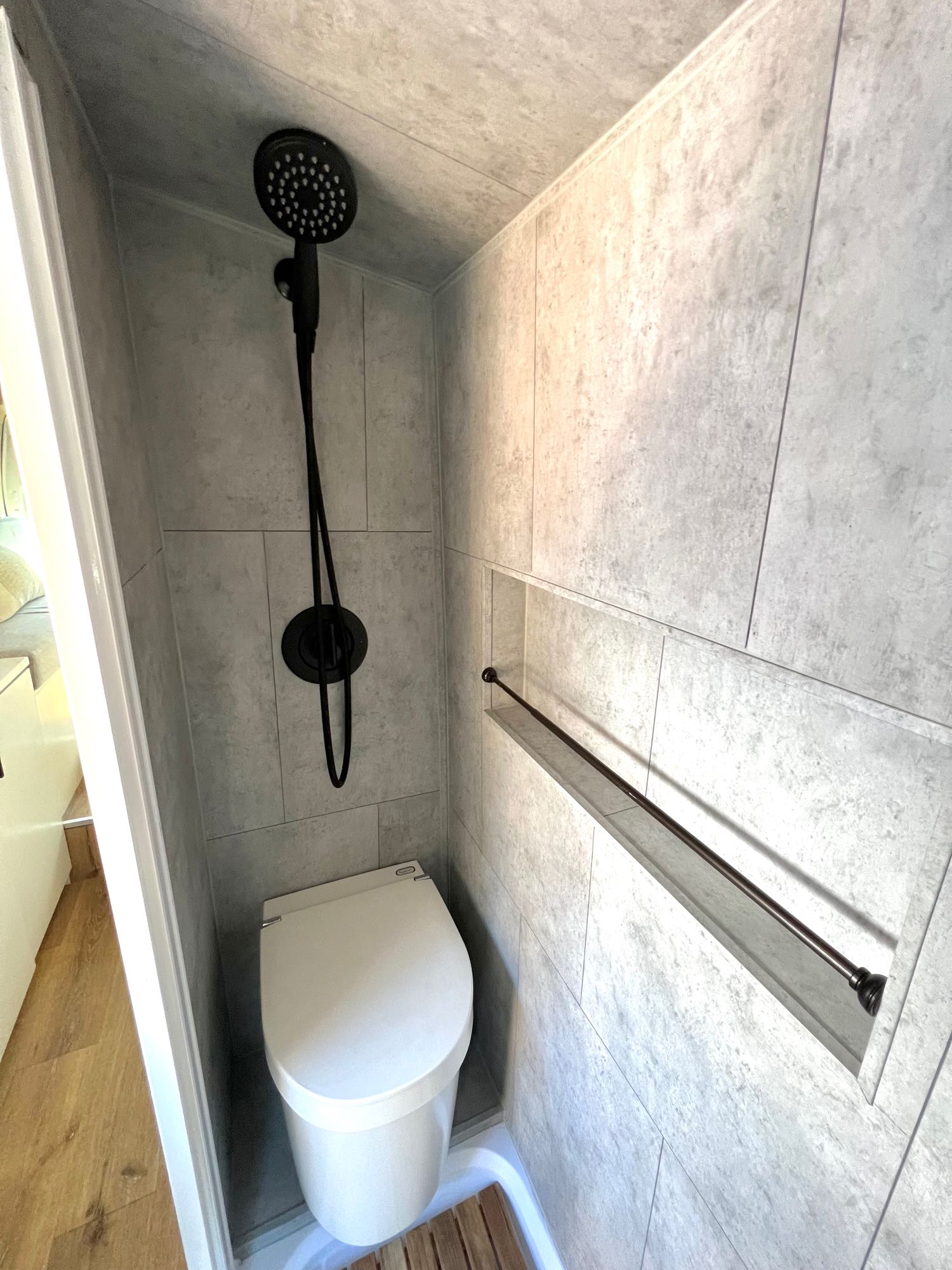 with a white RV rental camper van parked nearby under a vibrant sky.|Modern RV rental bathroom featuring a shower