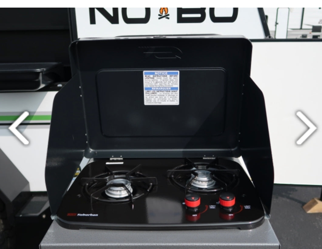 This open, black two-burner outdoor stove, ideal for an RV rental, features red control knobs and is ready for camp cooking.