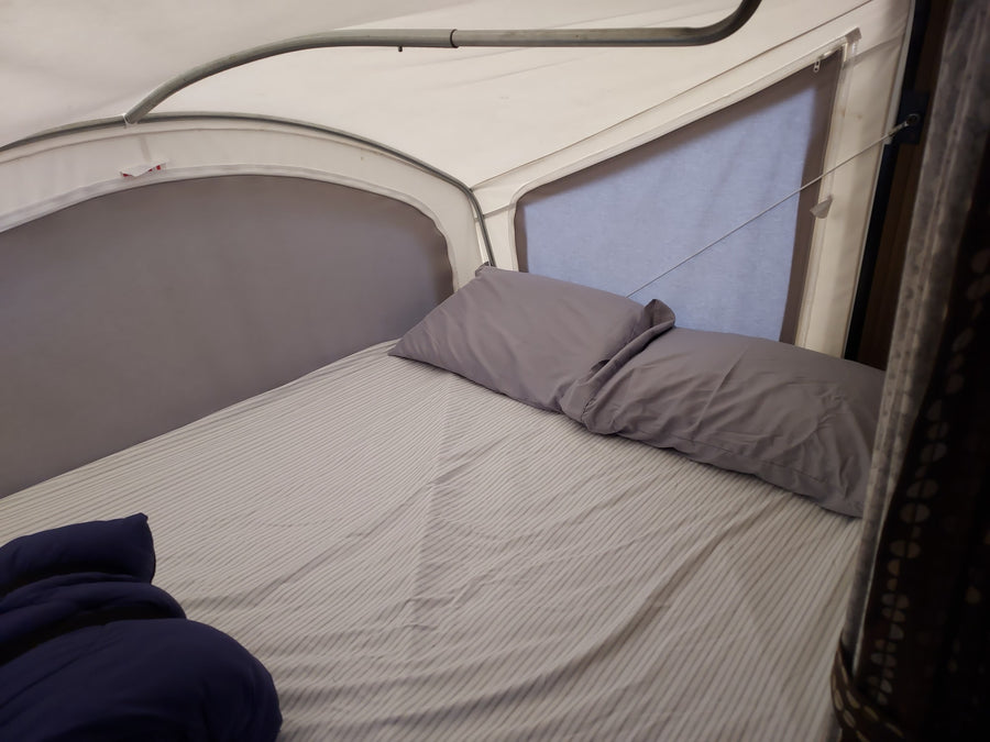 convertible din|Spacious **|RV rental interior: a cozy bed with striped sheets