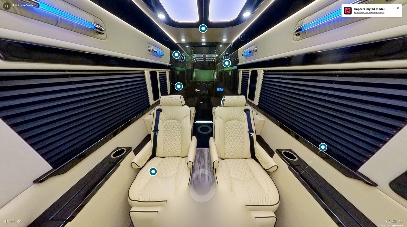 and an overhead screen displaying news.|Plush cream leather interior of a luxury RV rental