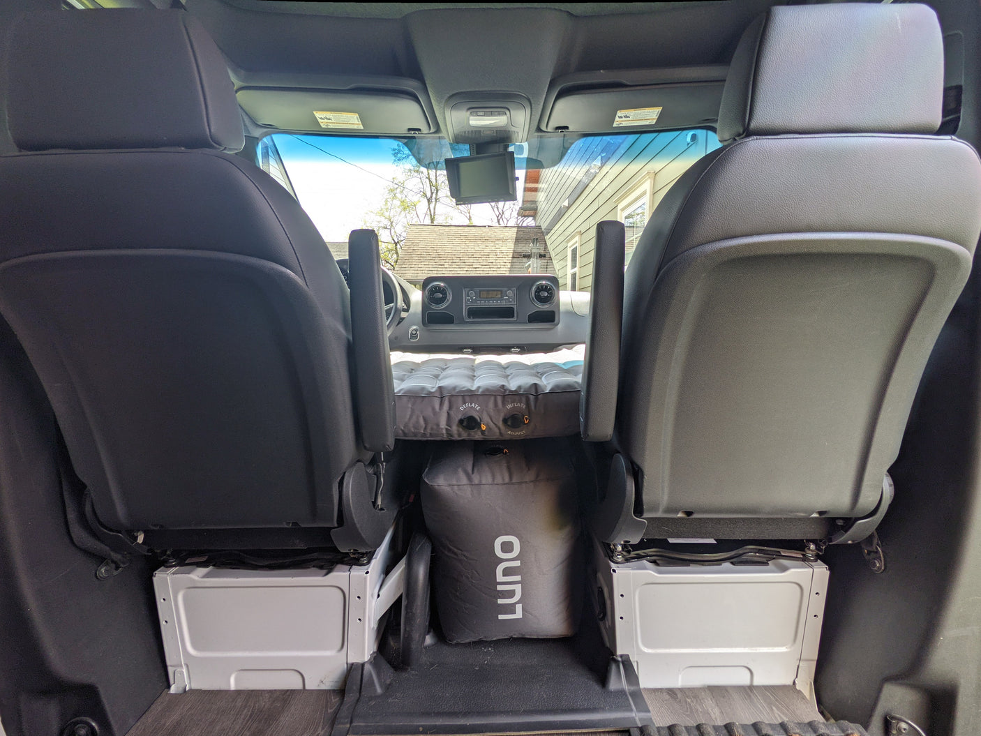 Cozy rv rental setup: an inflatable mattress fits perfectly between front seats for a comfortable night in this camper van.