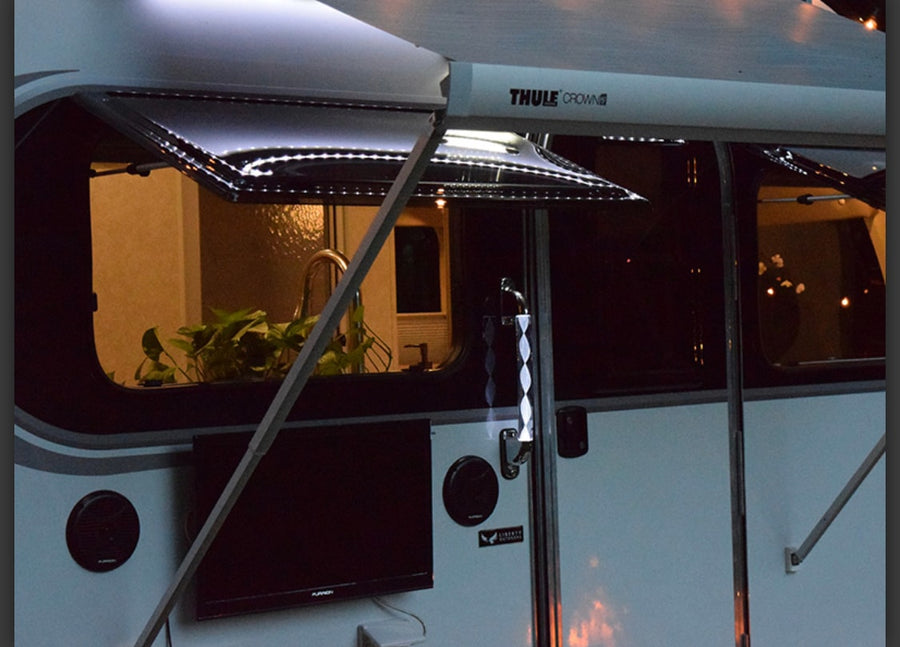 Experience night comfort in your RV rental! An LED-lit awning illuminates the outdoor TV and cozy interior.