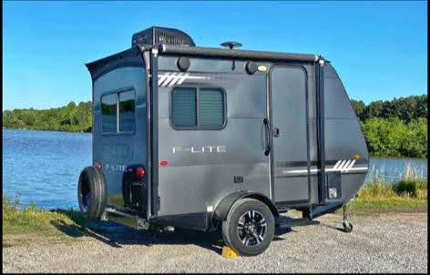 Gray F-Lite travel trailer by a lake