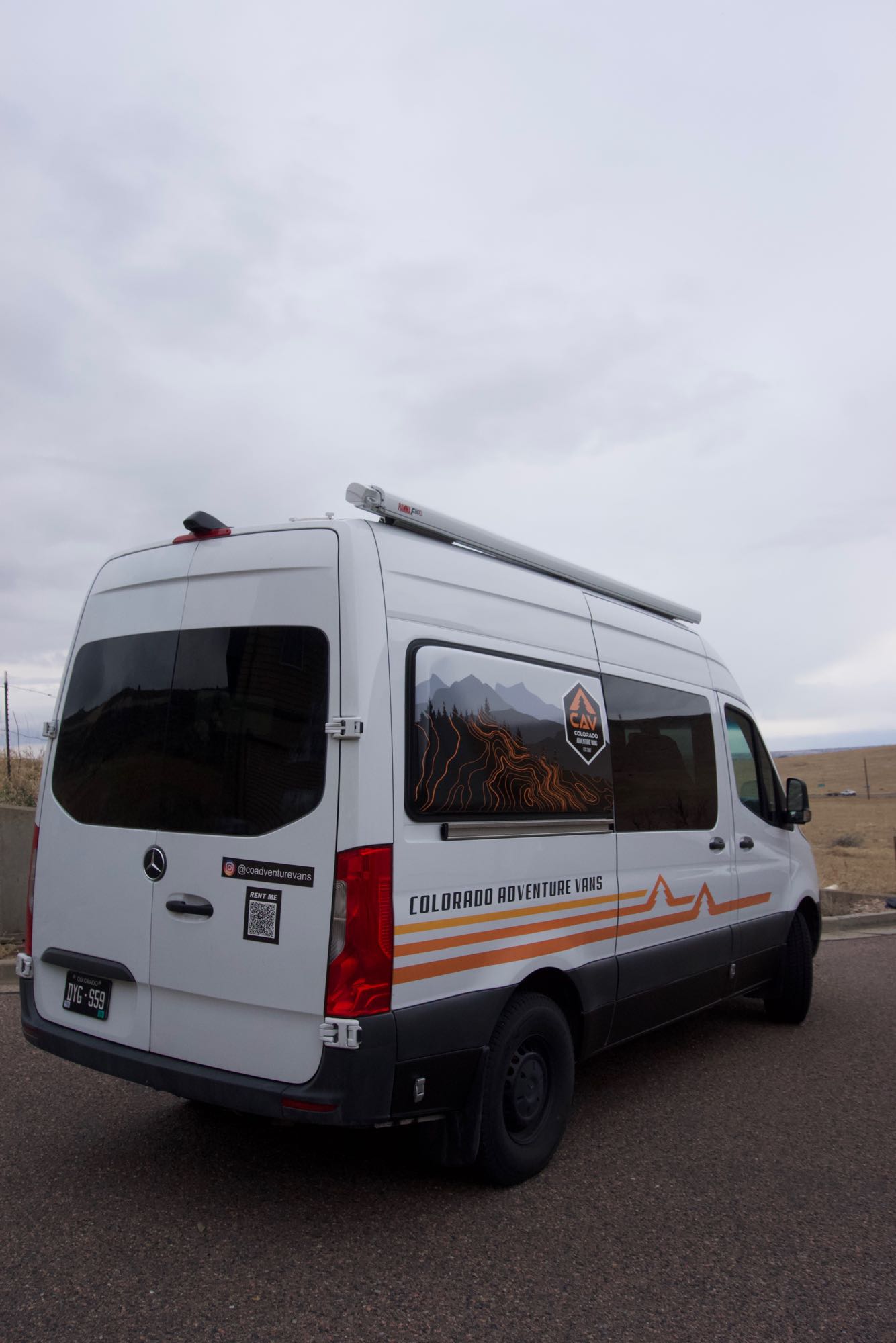 alongside custom wooden storage. Perfect for camper van travel.|RV rental interior: A compact