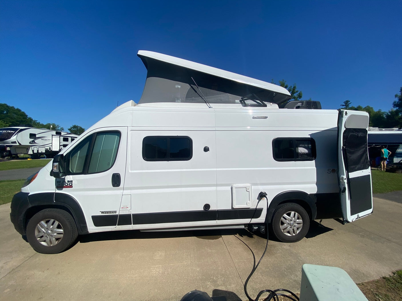 and flexible living space.|Interior of an RV rental showing a ladder to a pop-top roof