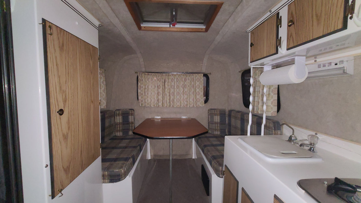 Cozy RV rental interior with dinette, kitchen, and ample storage, perfect for your next adventure.