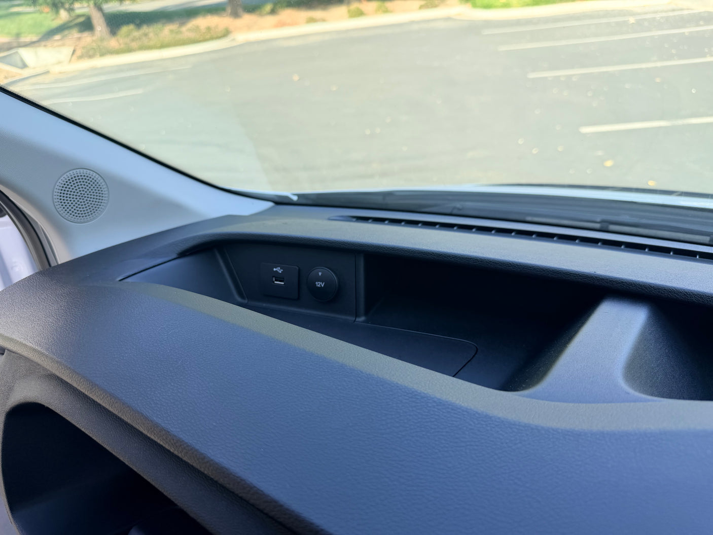 RV rental dashboard: Close-up of interior showing a speaker, USB port, and 12V outlet for charging devices.