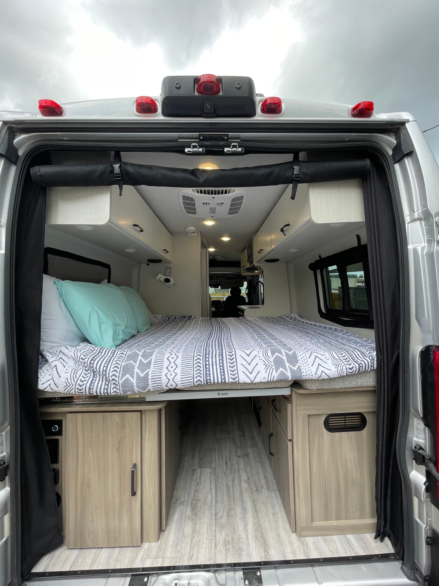 and a bed area further back.|Bright RV rental interior with swivel front seats