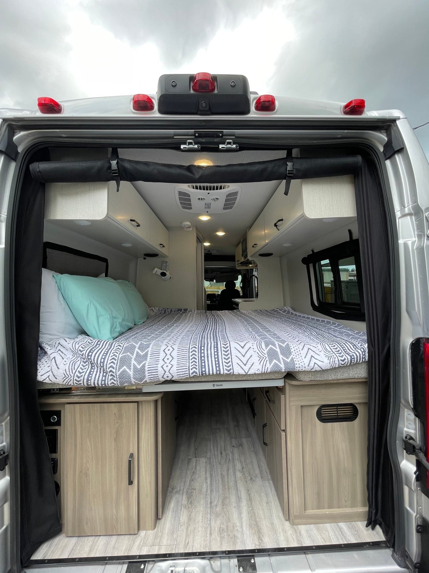 and a bed area further back.|Bright RV rental interior with swivel front seats
