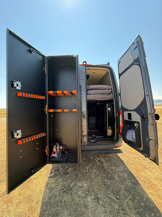 Inside this RV rental van: custom storage unit with orange racks, a comfy bed, perfect for gear & rest on the go.