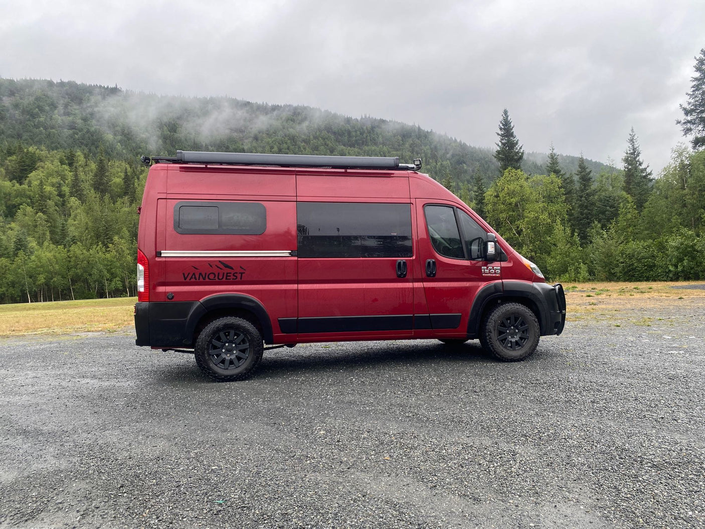 a woman helps a child buckle into a car seat.|RV rental power control: A black light switch & Renogy panel with ON/OFF switch & indicator lights on a grey wall.|Stainless GSI cookset with orange grips on a portable induction stove